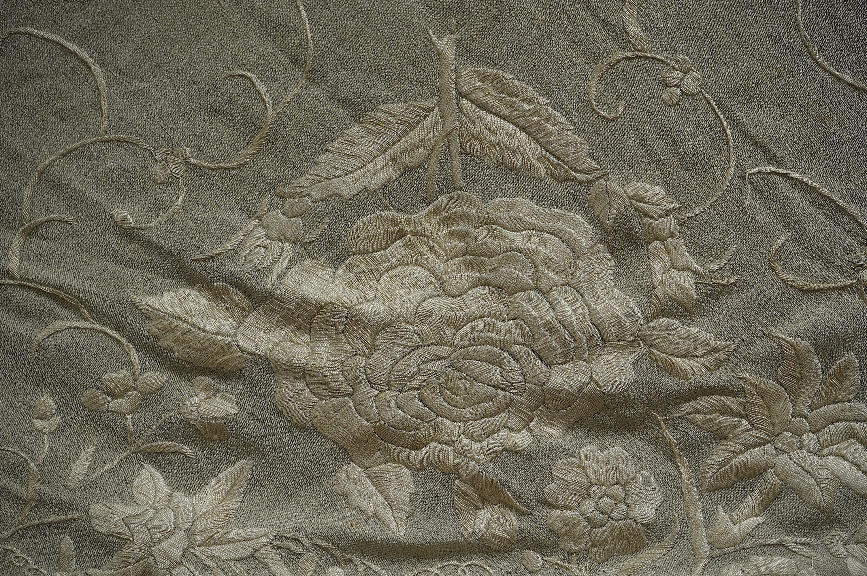 Two Chinese embroidered silk fringed shawls, one cream floral embroidery on cream silk, the other polychrome silk embroidered with figures on black silk, black shawl 130cm x 136cm, cream shawl 128cm x 168cm. Condition -